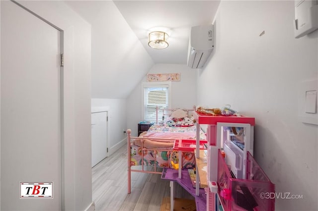 bedroom featuring lofted ceiling, a wall unit AC, and wood finished floors