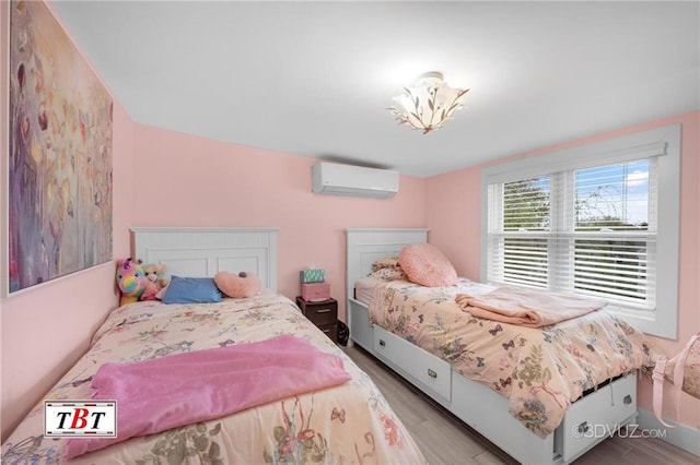 bedroom with wood finished floors and a wall mounted AC