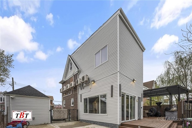 back of house with a gate, fence, a deck, and a pergola