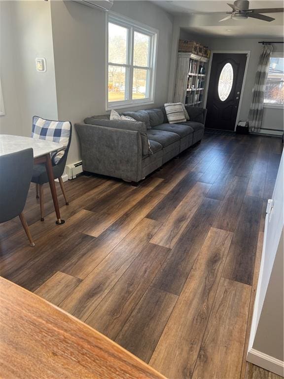 living room featuring a baseboard radiator, baseboards, dark wood finished floors, and a ceiling fan