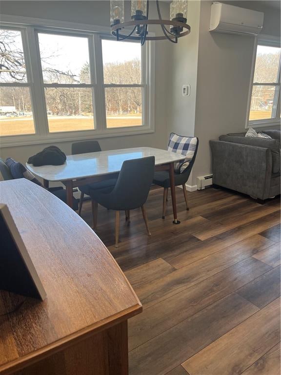 dining space featuring a baseboard heating unit, a chandelier, dark wood-style flooring, and a wall unit AC