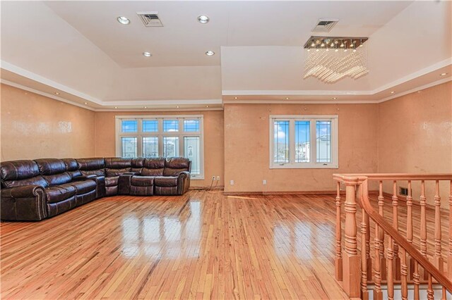 living area featuring a tray ceiling, recessed lighting, visible vents, and wood-type flooring