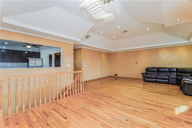 interior space featuring visible vents, a tray ceiling, and wood finished floors