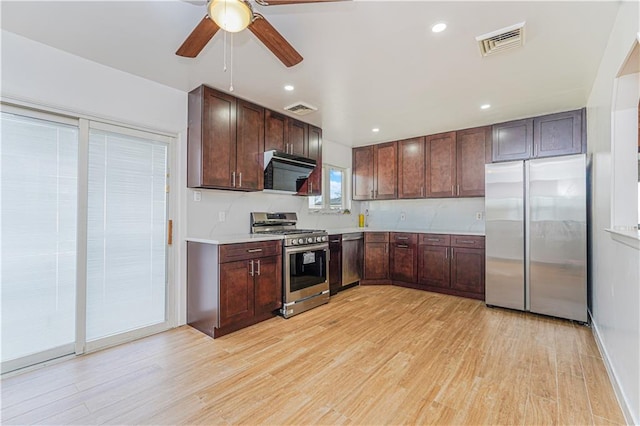 kitchen with light wood-type flooring, stainless steel appliances, visible vents, and light countertops