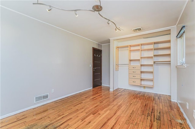 unfurnished bedroom featuring a closet, visible vents, light wood-type flooring, and baseboards