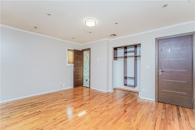 unfurnished bedroom with visible vents, baseboards, crown molding, and light wood finished floors