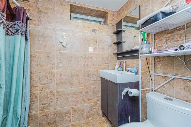 bathroom with toilet, tile walls, and vanity