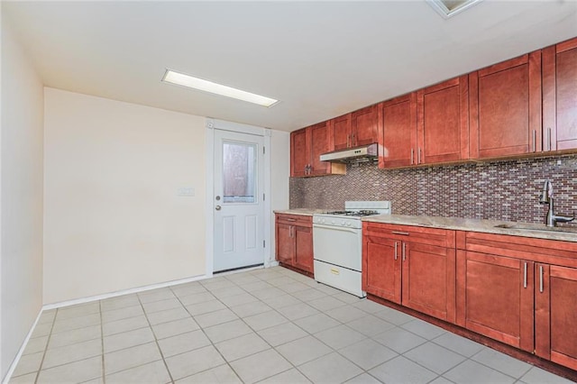 kitchen with a sink, decorative backsplash, under cabinet range hood, and white gas stove