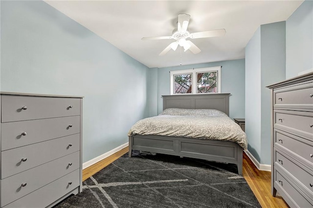 bedroom featuring wood finished floors, a ceiling fan, and baseboards