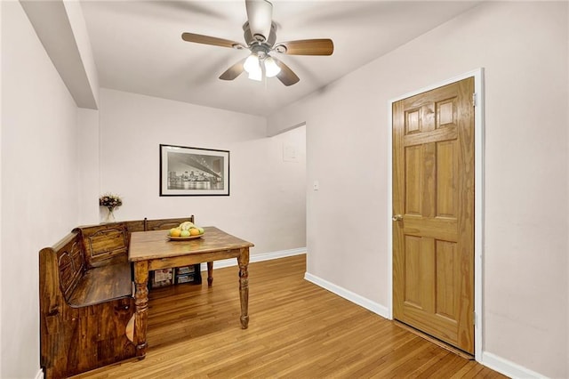 dining space with light wood-style floors, ceiling fan, and baseboards