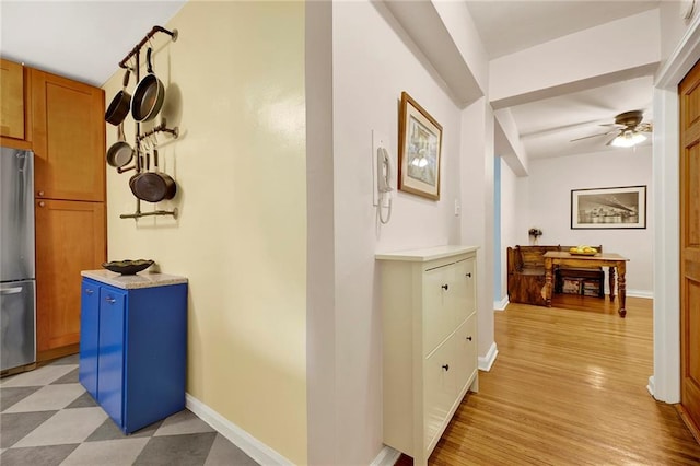 hall featuring light floors and baseboards