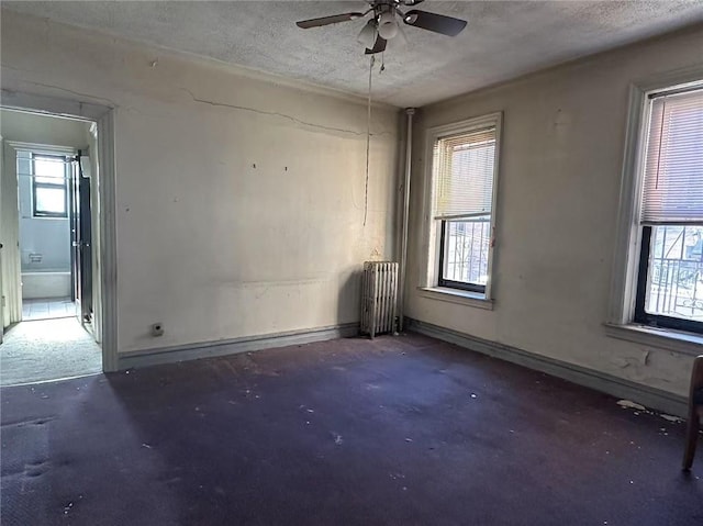 730 57th St Unit 2A, Brooklyn, NY 11220 - spare room with radiator, concrete flooring, a textured ceiling, ceiling fan, and baseboards
