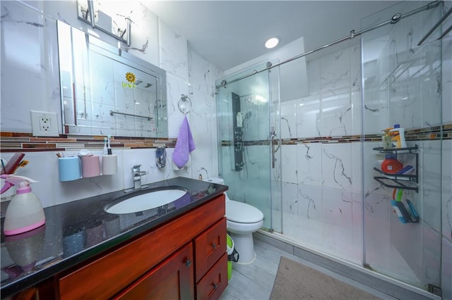 bathroom featuring decorative backsplash, a stall shower, vanity, and toilet