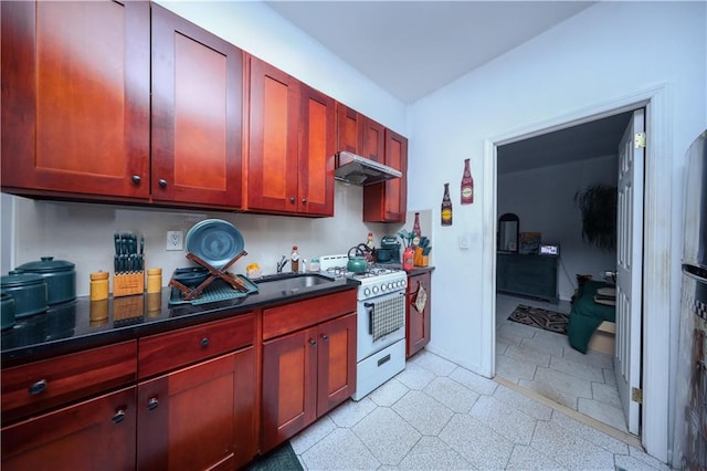 kitchen with under cabinet range hood, white range with gas stovetop, a sink, baseboards, and dark brown cabinets