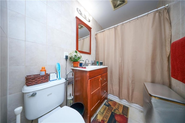 full bathroom featuring tile walls, visible vents, toilet, vanity, and a shower with curtain