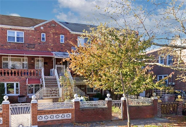 view of front of house featuring a fenced front yard, a gate, and brick siding