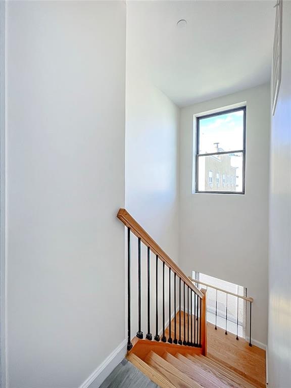 stairway featuring wood finished floors and baseboards