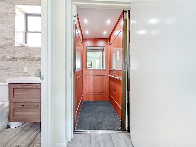 hall with wood finish floors and a sink