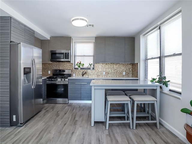 kitchen with modern cabinets, visible vents, stainless steel appliances, and light countertops