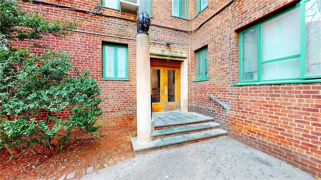 doorway to property featuring french doors and brick siding