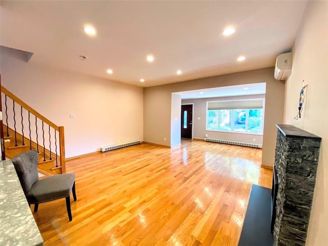 living area with a wall mounted air conditioner, light wood finished floors, recessed lighting, stairs, and baseboards