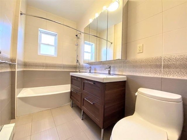 full bath with tile walls, toilet, washtub / shower combination, vanity, and tile patterned floors