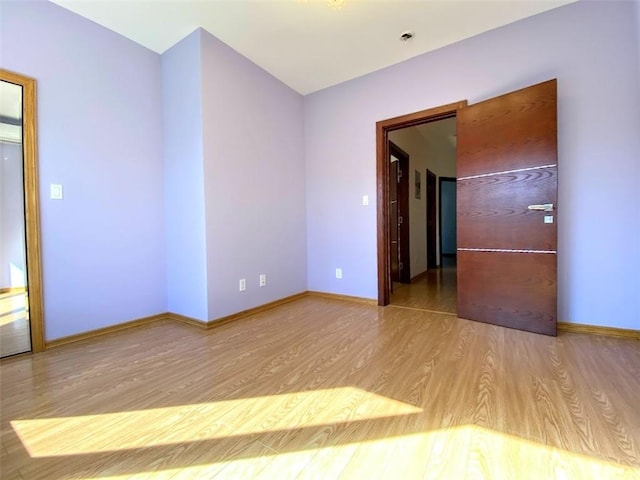 unfurnished room featuring wood finished floors and baseboards