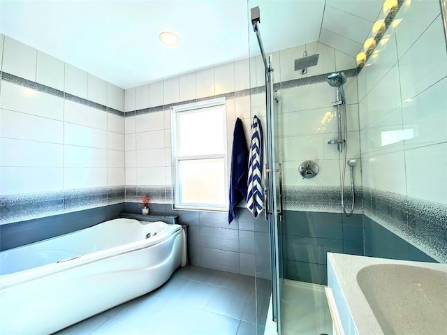 full bath featuring tile walls, a shower stall, a garden tub, and tile patterned flooring