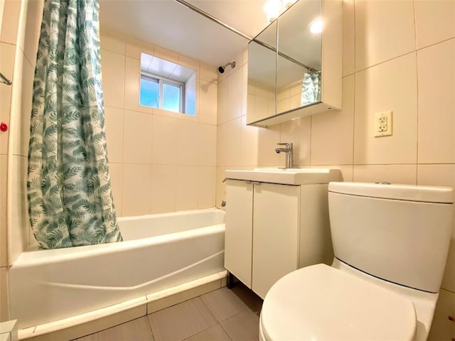 bathroom with toilet, shower / tub combo with curtain, tile patterned flooring, vanity, and tile walls