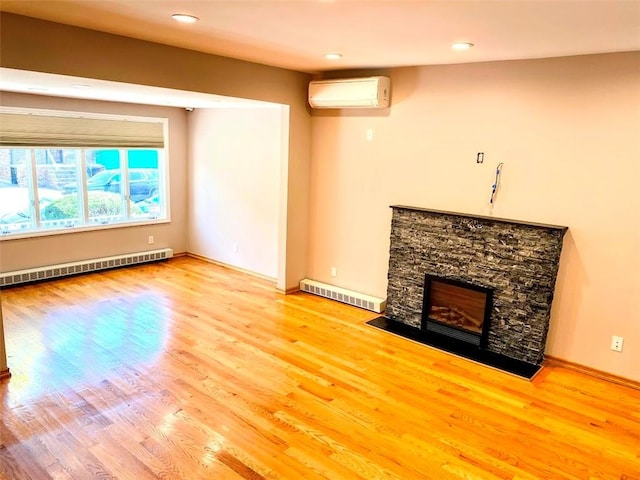 unfurnished living room featuring a baseboard heating unit, a fireplace, wood finished floors, visible vents, and an AC wall unit