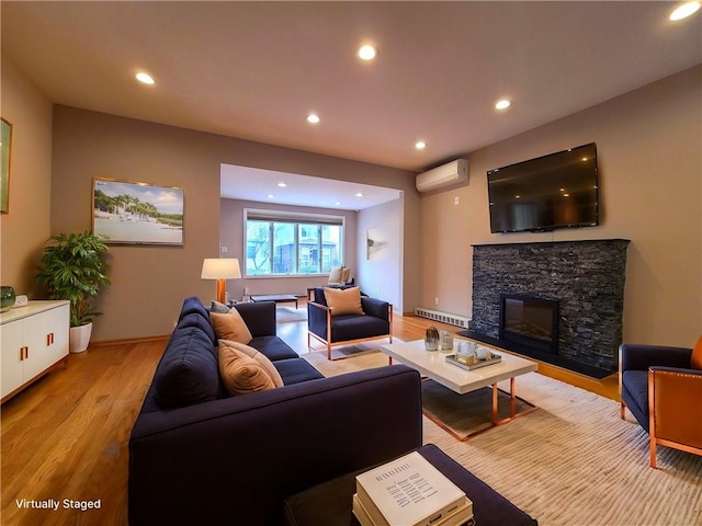 living room featuring an AC wall unit, light wood-style floors, a fireplace, recessed lighting, and a baseboard heating unit