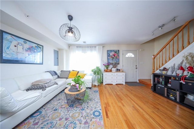 living area with stairs and wood finished floors