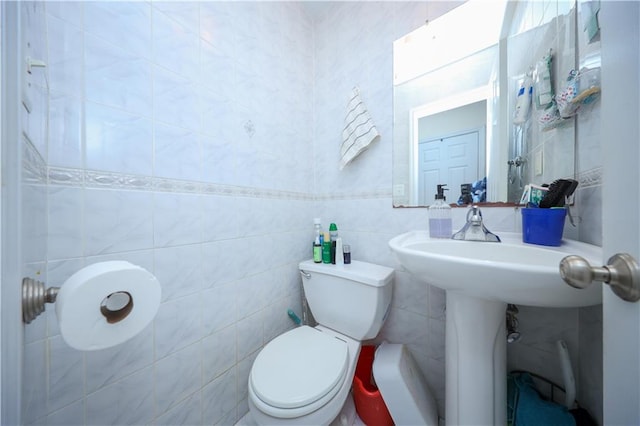 half bathroom with toilet and tile walls