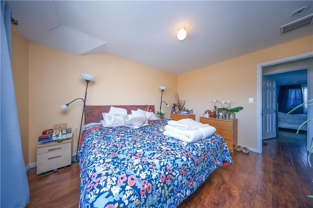 bedroom featuring baseboards, lofted ceiling, wood finished floors, and visible vents
