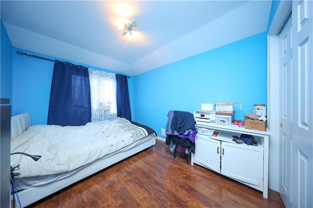 bedroom featuring dark wood-type flooring and lofted ceiling