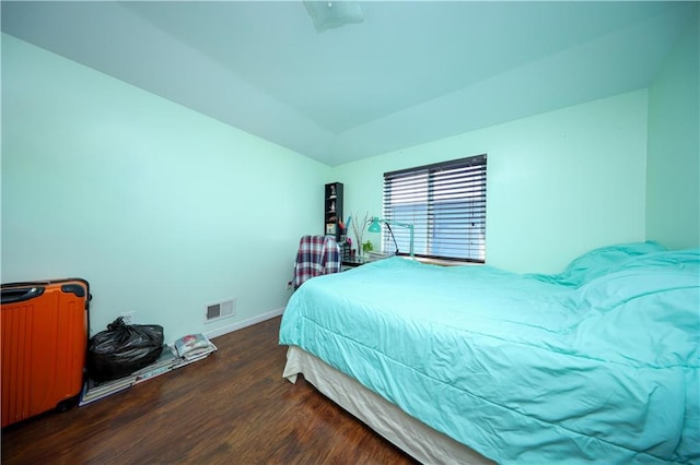 bedroom with baseboards, visible vents, and wood finished floors