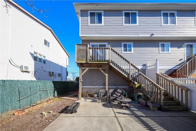 rear view of property featuring a fenced backyard, a patio, ac unit, and stairs