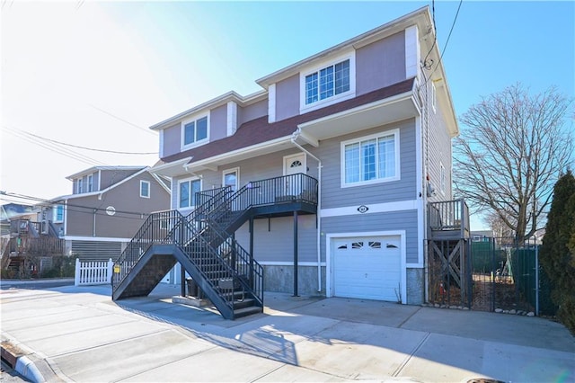 view of front facade featuring stairs, an attached garage, fence, and concrete driveway