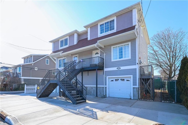 view of front of home with driveway, an attached garage, and stairway