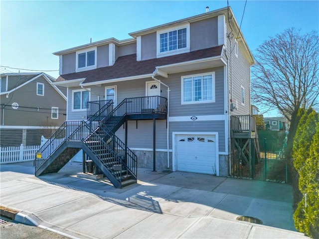 view of front of property with stairs, a garage, and driveway