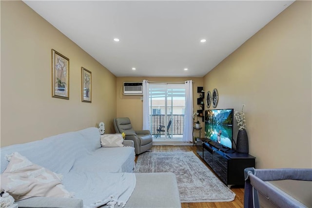 living area featuring recessed lighting, an AC wall unit, and wood finished floors