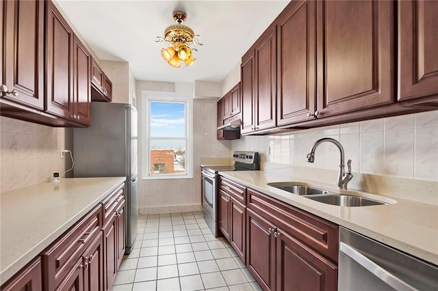 kitchen with backsplash, stainless steel appliances, a sink, and light tile patterned flooring