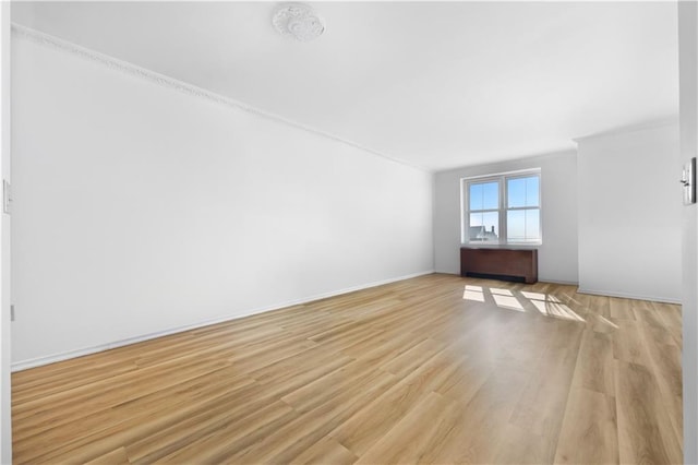 spare room featuring light wood-type flooring and baseboards