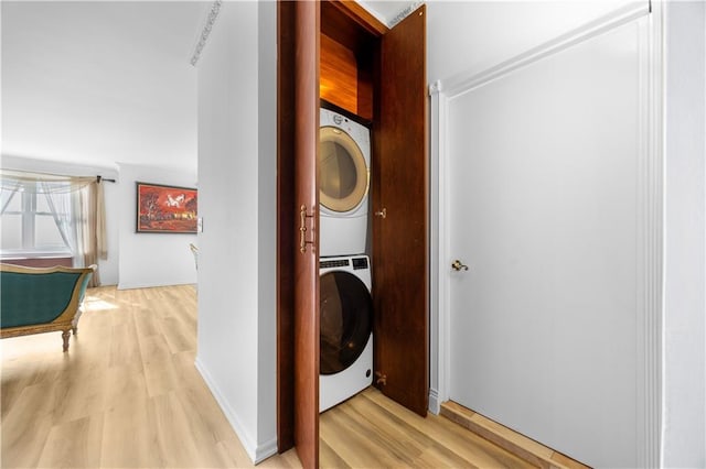 washroom with light wood finished floors, laundry area, and stacked washer and clothes dryer