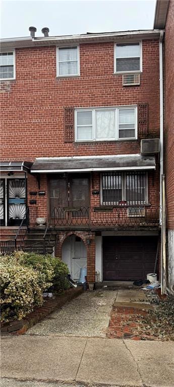 back of house with a garage and brick siding