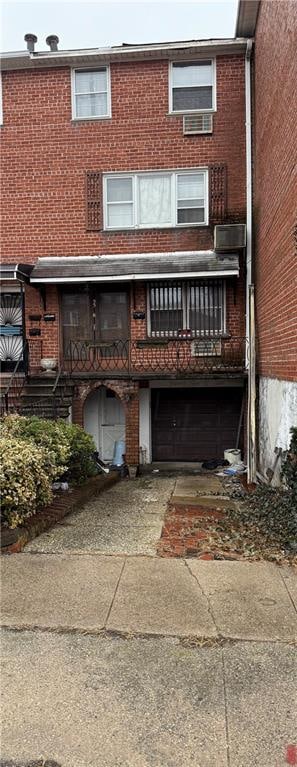 rear view of property with driveway and brick siding