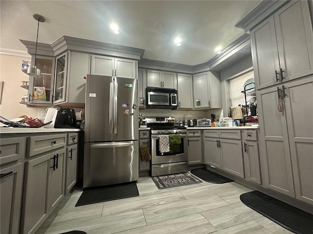 kitchen with gray cabinets, stainless steel appliances, light countertops, and decorative light fixtures