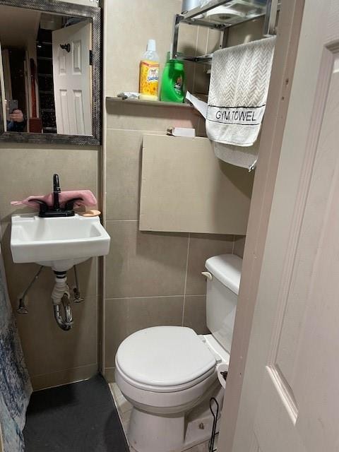 2195 Linden Blvd, Brooklyn, NY 11207 - bathroom featuring toilet, a sink, tile walls, and tile patterned floors