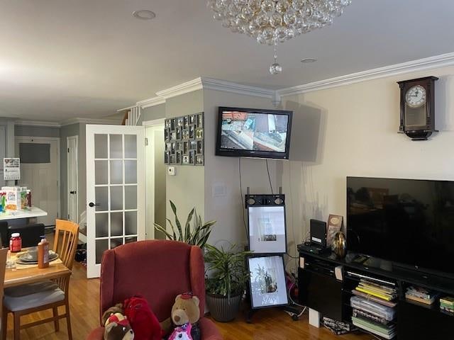 living area with wood finished floors and ornamental molding