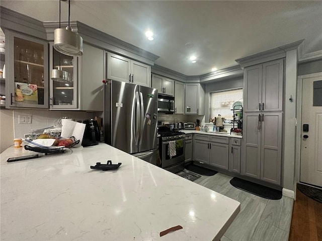 2195 Linden Blvd, Brooklyn, NY 11207 - kitchen with appliances with stainless steel finishes, gray cabinetry, crown molding, glass insert cabinets, and light stone countertops